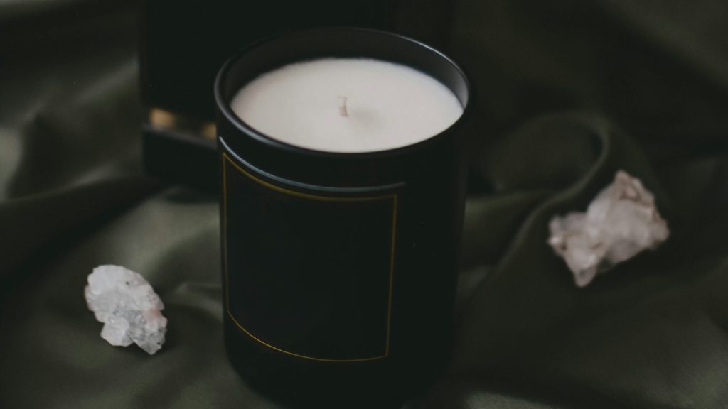 a candle sitting on top of a bed next to a box