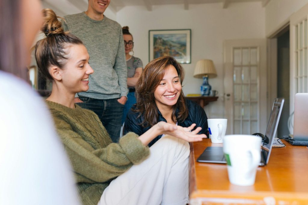 A group of friends enjoying casual leisure time indoors with smiles and relaxed atmosphere.